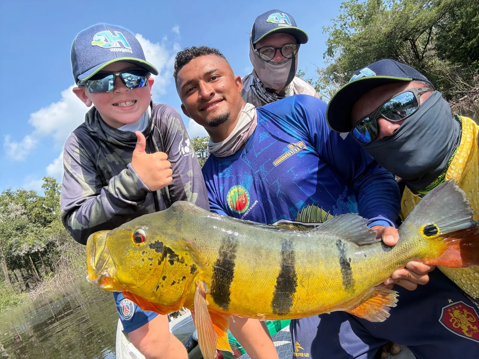 Grupo de pescadores reunido com um grande tucunaré