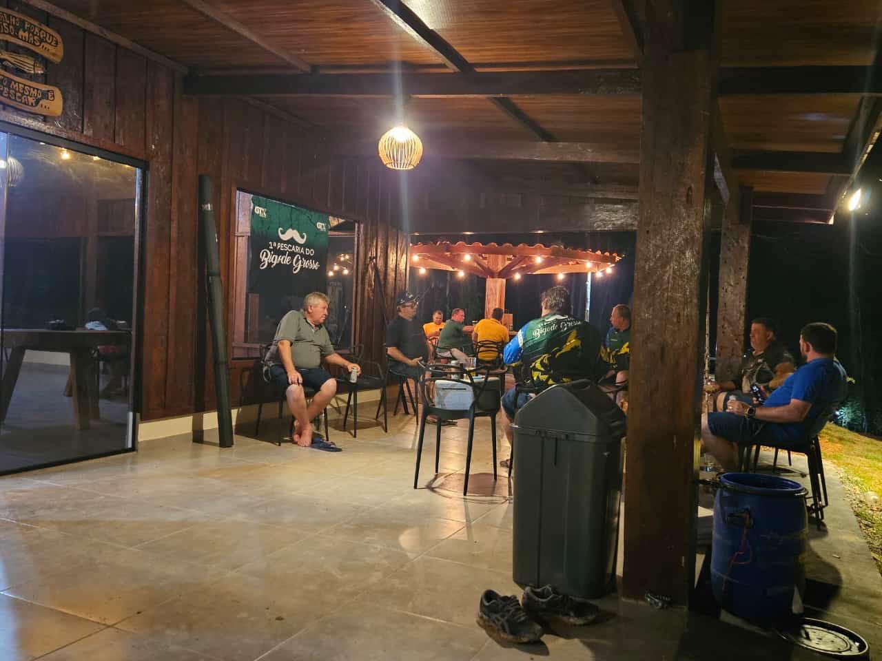 Pescadores reunidos na área externa da pousada à noite