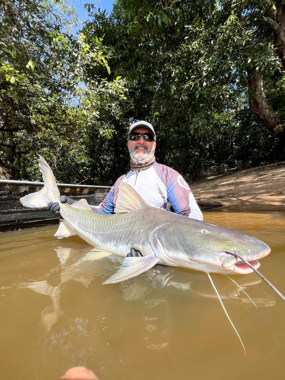 Pescador exibe uma captura nas águas do rio