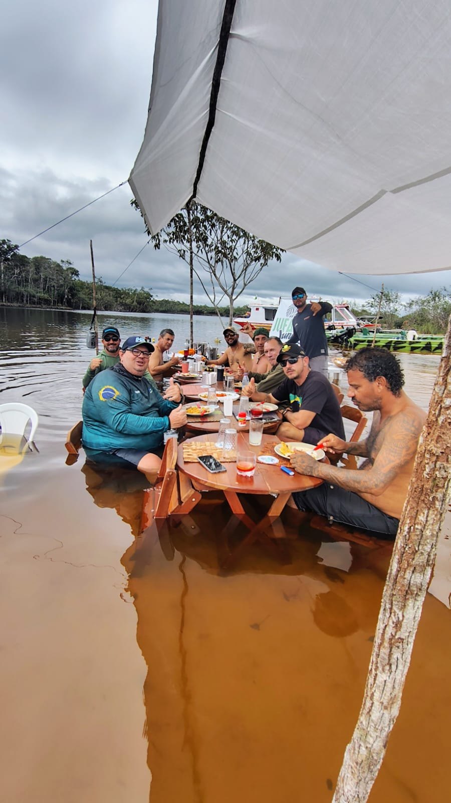 Pescadores reunidos para refeição à beira do Rio Jufari