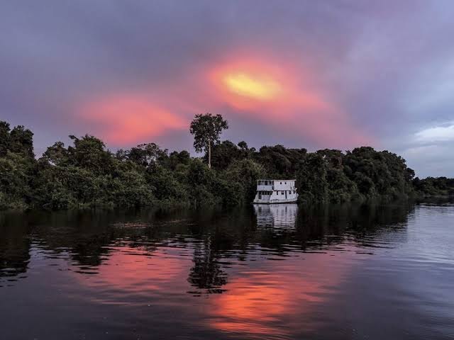 Pôr do sol sobre o rio e a floresta na região da Pousada Triple Border