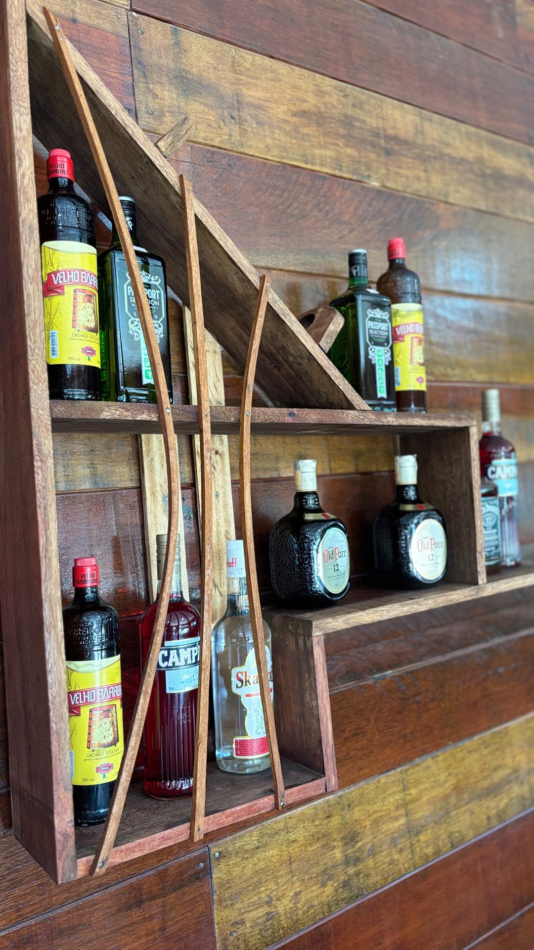 Garrafas de bebidas em prateleira de madeira